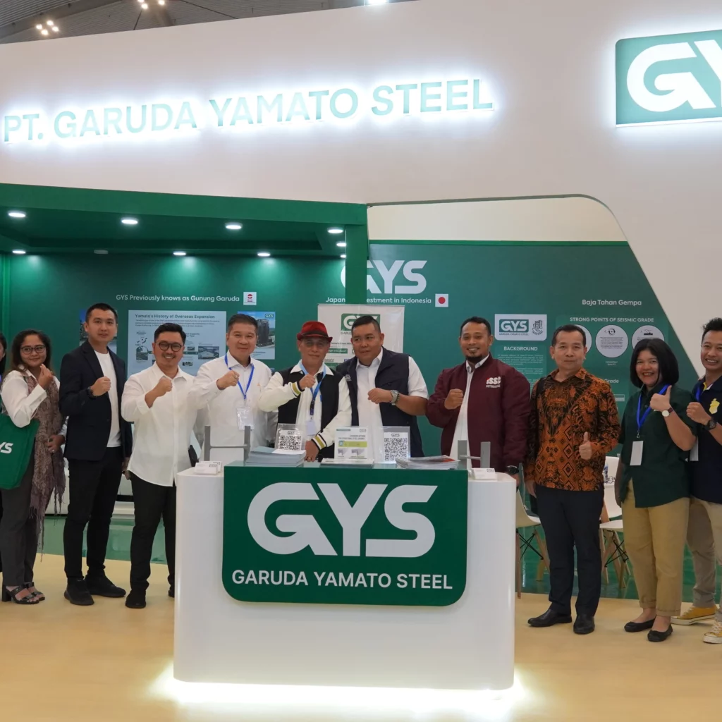 PT Garuda Yamato Steel (GYS) team at Konstruksi Indonesia 2024 booth showcasing high-quality structural steel products, including Earthquake-Resistant Steel, with GYS representatives posing in front of the booth for a group photo.